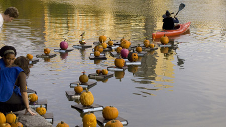 Pumpkin lanterns, or Jack-o'-lanterns, float on the water in Central Park of New York, U.S., Oct. 25, 2009. People took part in the annual Pumpkin Sail on Sunday to celebrate the coming Halloween. (Xinhua/Liu Xin)