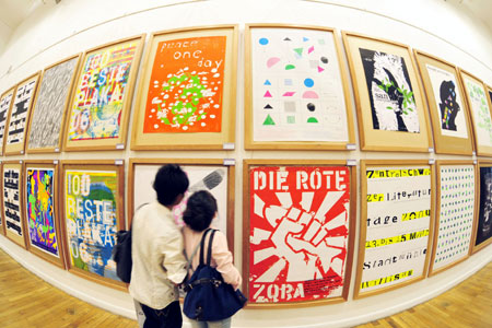 Visitors look at exhibited posters during the 4th China International Poster Biennial Exhibition held in Hangzhou, capital of east China's Zhejiang Province, Oct. 26, 2009. A total of 178 poster works were shown in the exhibition, which kicked off at the gallery of China Academy of Art in Hangzhou on Monday.