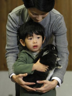 Japan's Prince Hisahito holds a rabbit with his mother Princess Kiko as they visit the Ueno Zoological Gardens in Tokyo October 26, 2009.(Xinhua/Reuters Photo)