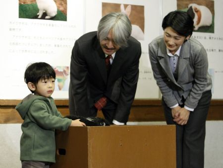 Japan's Prince Hisahito (L) touches a rabbit as his parents Prince Akishino (C) and Princess Kiko look on during their visit at the Ueno Zoological Gardens in Tokyo October 26, 2009.(Xinhua/Reuters Photo)