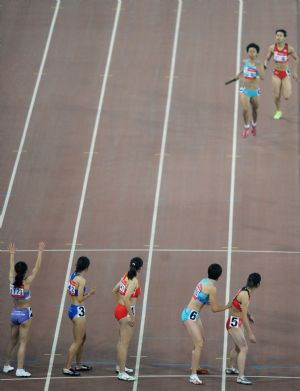 Athletes compete during the women's 4X400m relay final of athletics at the 11th Chinese National Games in Jinan, capital of east China's Shandong Province, Oct. 26, 2009. The team of Guangdong claimed the title with 3:30.63. (Xinhua/Li Ga)