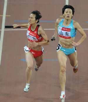 Chen Jingwen (L) from Guangdong Province sprints with Huang Xiaoxiao of Shandong during the women's 4X400m relay final of athletics at the 11th Chinese National Games in Jinan, capital of east China's Shandong Province, Oct. 26, 2009. (Xinhua/Li Ga)