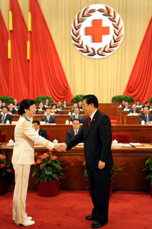 Hu Jintao (R front), Chinese president and honorary president of the Red Cross Society of China (RCSC), shakes hands with Wang Wenzhen, a Chinese laureate of the 42nd Florence Nightingale Award, who is a head nurse of the general hospital of the People's Liberation Army navy, during the opening ceremony of the 9th national conference of the RCSC in Beijing, capital of China, Oct. 27, 2009. Chinese President Hu Jintao, who is also general secretary of the Communist Party of China (CPC) Central Committee and chairman of the Central Military Commission, on Tuesday conferred the Florence Nightingale medal on laureated Chinese nurses for their outstanding contributions to healthcare. (Xinhua/Ma Zhancheng)
