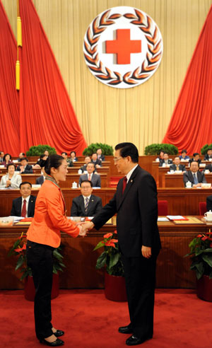 Hu Jintao (R, front), Chinese president and honorary president of the Red Cross Society of China (RCSC), shakes hands with Yang Qiu, a Chinese laureate of the 42nd Florence Nightingale Award, who is a nurse of the Xiang'e township hospital in Dujiangyan of southwest China's Sichuan Province, during the opening ceremony of the 9th national conference of the RCSC in Beijing, capital of China, Oct. 27, 2009. (Xinhua/Ma Zhancheng)