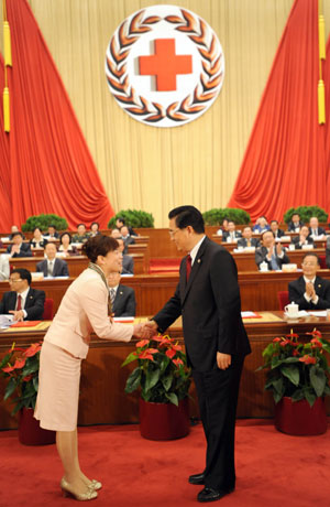 Hu Jintao (R, front), Chinese president and honorary president of the Red Cross Society of China (RCSC), shakes hands with Zhang Guiying, a Chinese laureate of the 42nd Florence Nightingale Award, who is a nurse of a hospital of psychopathy in northeast China's Jilin Province, during the opening ceremony of the 9th national conference of the RCSC in Beijing, capital of China, Oct. 27, 2009. (Xinhua/Ma Zhancheng)
