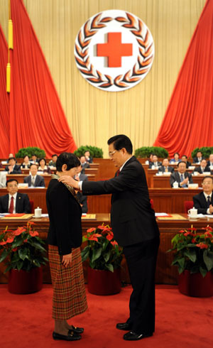 Hu Jintao (R, front), Chinese president and honorary president of the Red Cross Society of China (RCSC), awards a medal to Liu Shuyuan, a Chinese laureate of the 42nd Florence Nightingale Award, who is a head nurse of Beijing Anzhen Hospital, during the opening ceremony of the 9th national conference of the RCSC in Beijing, capital of China, Oct. 27, 2009. (Xinhua/Ma Zhancheng)