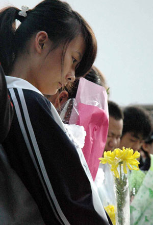 Students hold white chrysanthemum during a funeral to mourn for three college students in Jingzhou, a city of central China's Hubei Province, Oct. 28, 2009. A grand memorial service was held here Wednesday to honor three college students, Chen Jishi, He Dongxu and Fang Zhao, who died when rescuing two children from the Yangtze River on Oct. 24. Thousands of people took part in the funeral to see off the three teenagers, all 19-year-old students from the Yangtze University based in Jingzhou City. 