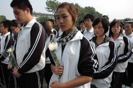 Students hold white chrysanthemum during a funeral to mourn for three college students in Jingzhou, a city of central China's Hubei Province, Oct. 28, 2009. A grand memorial service was held here Wednesday to honor three college students, Chen Jishi, He Dongxu and Fang Zhao, who died when rescuing two children from the Yangtze River on Oct. 24. Thousands of people took part in the funeral to see off the three teenagers, all 19-year-old students from the Yangtze University based in Jingzhou City. 