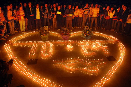 Students from Yangtze University in Jingzhou of central China's Hubei province kindle candles to mourn for the death of three students who sacrificed their lives to save two drowning children on Oct 27, 2009. [CFP]