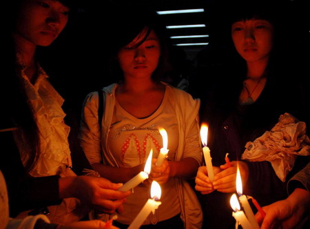 Students from Yangtze University kindle candles to mourn for the death of three students, Chen Jishi, He Dongxu and Fang Zhao, who sacrificed their lives saving two drowning children at Yangtze University Oct 27, 2009.[Xinhua] 
