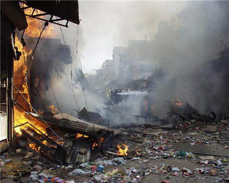 People gather around the site of an explosion in northwest Pakistan's city of Peshawar, Oct. 28, 2009. At least 80 people were killed and more than 200 others injured in a powerful bomb blast at a crowded market in Peshawar on Wednesday.