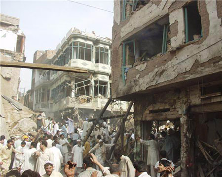 People gather around the site of an explosion in northwest Pakistan's city of Peshawar, Oct. 28, 2009. At least 80 people were killed and more than 200 others injured in a powerful bomb blast at a crowded market in Peshawar on Wednesday.