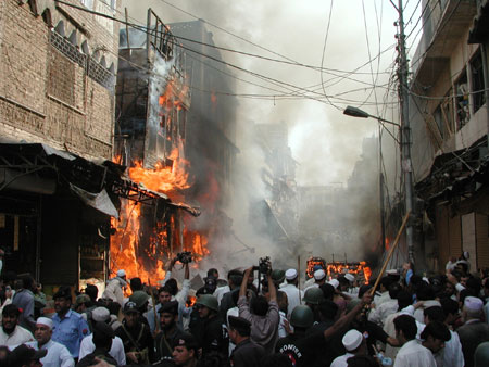 People gather around the site of an explosion in northwest Pakistan's city of Peshawar, Oct. 28, 2009. At least 80 people were killed and more than 200 others injured in a powerful bomb blast at a crowded market in Peshawar on Wednesday.