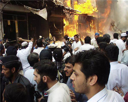 People gather around the site of an explosion in northwest Pakistan's city of Peshawar, Oct. 28, 2009. At least 80 people were killed and more than 200 others injured in a powerful bomb blast at a crowded market in Peshawar on Wednesday.