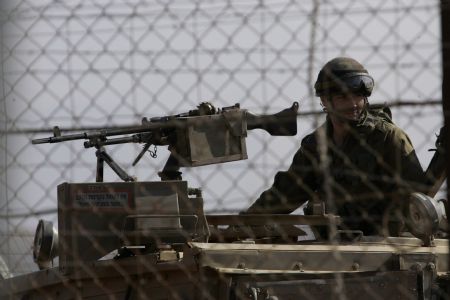 An Israeli soldier sits on a vehicle as he patrols the border with Lebanon near Kfarkila village in south Lebanon October 28, 2009. Lebanese army soldiers found and deactivated four rockets on Wednesday in the area from where a rocket had been fired towards northern Israel, witnesses said. 