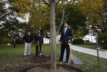 U.S. President Barack Obama (R) admires a newly planted commemorative tree with White House Chief Usher Rear Admiral Stephen W. Rochon (C) at the White House in Washington, October 28, 2009.(Xinhua/Reuters Photo)