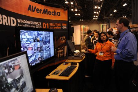 An exhibitor staff introduce a video monitoring system to a client at International Security Conference East 2009 in New York of the United States, Oct. 28, 2009.(Xinhua/Shen Hong)