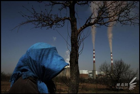 Shizuishan Industrial district in Ningxia province, the tall chimneys spitted out smoke and dust. Residents took preventive measure for the falling dust from the sky when going outside. April 22, 2006 