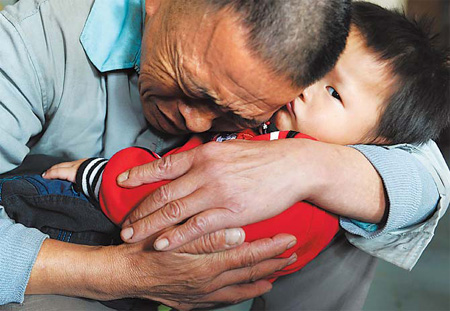 Wang Bangyin, a farmer from Zunyi, Guizhou province, breaks down as he holds his rescued son at Guiyang Welfare Center for Children yesterday after the pair were reunited. Wang's son was among 60 children seeking parents after police freed them from human traffickers. The Ministry of Public Security released photos of the children on Tuesday. Wang and his son were the first from the list to be reunited.