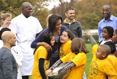 U.S. first lady Michelle Obama talks with students during the Fall Harvest of the White House Garden on the South Lawn of the White House in Washington, October 29, 2009.(Xinhua/Zhang Yan)