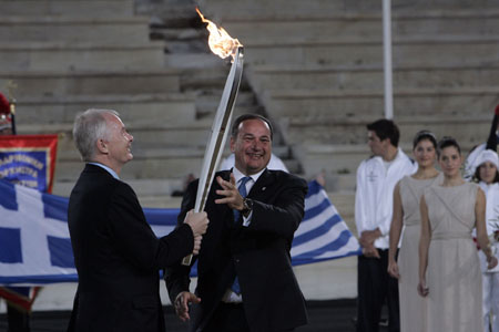 Vancouver 2010 Winter Olympic Games chief John Furlong (L) receives the Olympic Flame from the President of the Hellenic Olympic Committee Spiros Kapralos during the flame handing over ceremony for the Vancouver 2010 Winter Olympics.(Xinhua/Reuters Photo)