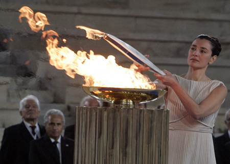 Greek actress Maria Nafpliotou, playing the role of high priestess, lights a torch during a handover ceremony in Athens at Panathenian stadium in Athens October 29,2009.(Xinhua/Reuters Photo)