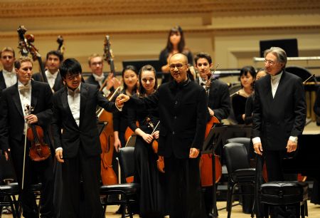 China's world acclaimed pianist Lang Lang (L front) and renowned Chinese composer Chen Qigang (C front) greet audience on the stage after a performance at Carnegie Hall in New York, the U.S., Oct. 28, 2009.(Xinhua/Gu Xinrong)