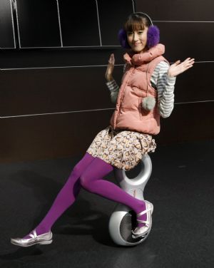 A model poses on the Honda Motor Co U3-X "personal transporter" electric unicycle at the 41st Tokyo Motor Show in Chiba, east of Tokyo October 21, 2009.(Xinhua/Reuters Photo)