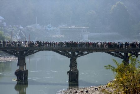 Kashmiri Muslim protesters cross a bridge during a protest rally in Baramulla, about 55 kilometers (34 miles) north of Srinagar, summer capital of Indian controlled Kashmir, Oct. 30, 2009. (Xinhua/Javed Dar)