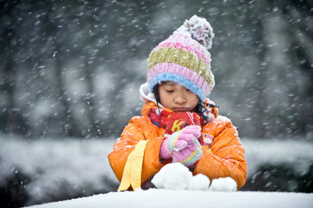 A girl makes snowballs in Beijing Nov. 1, 2009. The city's first snowfall this winter started Saturday night, bringing fresh air to locals as well as a sharp drop in temperature. (Xinhua/Wang Jianhua)