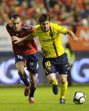 Osasuna's Patxi Punal (L) fights for the ball with Barcelona's Lionel Messi during their Spanish First Division soccer match at Reyno de Navarra stadium in Pamplona October 31, 2009.(Xinhua/Reuters Photo) 