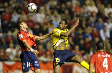 Osasuna's Josetxo Romero (L) leaps for the ball with Barcelona's Seydou Keita during their Spanish First Division soccer match at Reyno de Navarra stadium in Pamplona October 31, 2009.