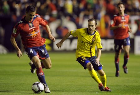 Osasuna's Masoud Shoujaei (L) fights for the ball with Barcelona's Andres Iniesta during their Spanish First Division soccer match at Reyno de Navarra stadium in Pamplona October 31, 2009.