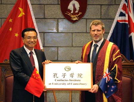 Visiting Chinese Vice Premier Li Keqiang (L) gives the tablet to Rod Carr, Vice-Chancellor of University of Canterbury, during the inauguration of Confucius Institute of University of Canterbury in Christchurch, New Zealand, Nov. 1, 2009.(Xinhua/Liu Jiansheng)