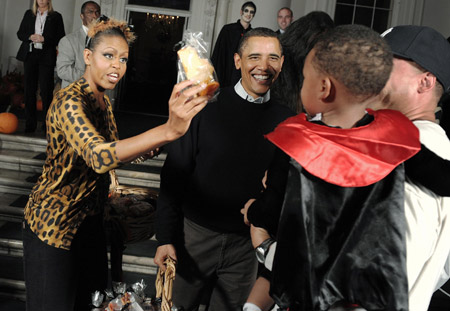 First lady Michelle Obama (L) comforts a crying child with the promise of a cookie as she and U.S. President Barack Obama (C) greet local school children on Halloween at the White House in Washington October 31, 2009.(Xinhua/Reuters Photo)