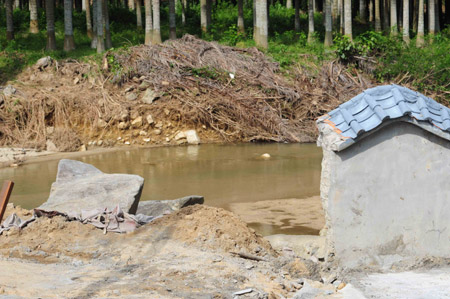 Photo taken on Oct. 31, 2009 shows the collapsed wall breach on the bank of the reservoir of the crocodile-breeding aquafarm in Huangshan Reservoir, Changfeng Township, Wanning City, south China's Hainan Province, Oct. 31, 2009. (Xinhua/Meng Zhongde)