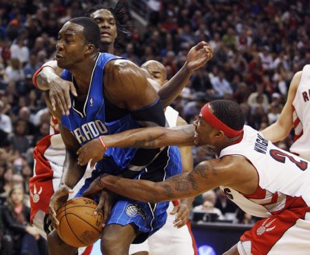 Orlando Magic center Dwight Howard (L) is double teamed by Toronto Raptors forwards Chris Bosh and Antoine Wright (R) during the second half of their NBA basketball game in Toronto November 1, 2009. Bosh drew a foul on the play.(Xinhua/Reuters Photo)