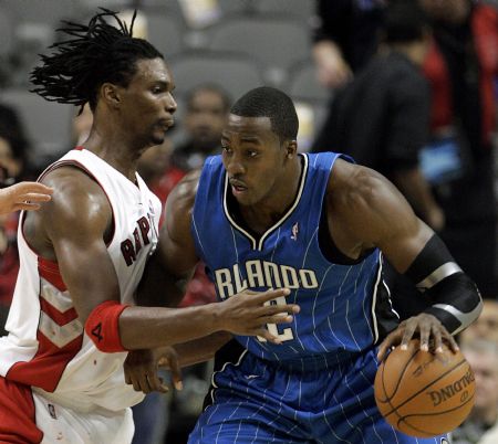 Orlando Magic center Dwight Howard works to the basket against Toronto Raptors forward Chris Bosh (L) during the first half of their NBA basketball game in Toronto November 1, 2009.(Xinhua/Reuters Photo)