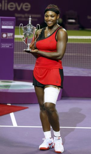 Serena Williams of U.S. holds her trophy after defeating her sister Venus Williams in the WTA Tour Championships final tennis match in Doha November 1, 2009.(Xinhua/Reuters Photo)