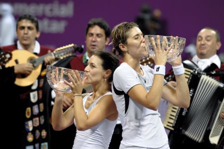 Maria Jose Martinez Sanchez (R) and compatriot Nuria Llagostera Vives of Spain kiss their champion trophies after defeating Cara Black of Zimbabwe and Liezel Huber of the U.S. during the final match of women's doubles at the WTA Tour Championships in Doha, Qatar, Nov. 1, 2009. Sanchez/Vives won 2-1.(Xinhua/Chen Shaojin)