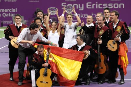 Maria Jose Martinez Sanchez (C,R) and compatriot Nuria Llagostera Vives of Spain hold up their champion trophies with a band of Spanish fans after winning over Cara Black of Zimbabwe and Liezel Huber of the U.S. during the final match of women's doubles at the WTA Tour Championships in Doha, Qatar, Nov. 1, 2009.(Xinhua/Chen Shaojin)