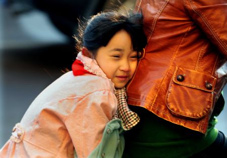 A girl hides herself behind her mother on the way to school in Zhengzhou, capital of central China's Henan Province, Nov. 2, 2009. The temperature plummeted all over the province and reached zero degree Celsius in Zhengzhou in the early morning of Monday. (Xinhua/Wang Song)