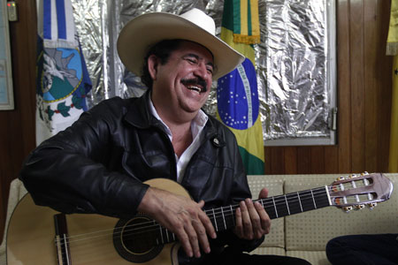 Honduras' ousted President Manuel Zelaya smiles as he holds a guitar during his relatives' visit, inside the Brazilian embassy in Tegucigalpa November 1, 2009. (Xinhua/Reuters Photo)