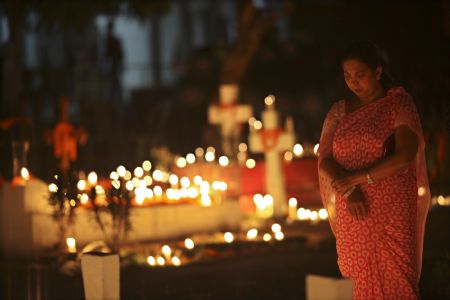 A Christian woman offers prayers for her departed loved ones on All Souls' Day at the cemetery of Holy Rosary church in Dhaka November 2, 2009.