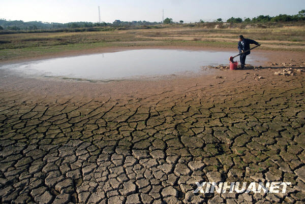 A farmer gets water from an almost dry pond at Zuishang Village of Tongjia Town in Yingtan, a city of southeast China&apos;s Jiangxi province, Nov. 3, 2009. [Xinhua]