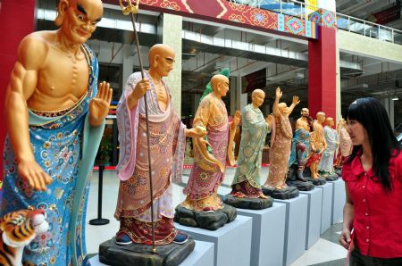 A visitor views clay sculpture works on the Buddhism Expo held in Putian, southeast China's Fujian Province, Nov. 2, 2009. The four-day-long China Putian Buddhism Expo kicked off here on Monday with nearly 10,000 exhibits on shown. (Xinhua/ Lin Jianbing)