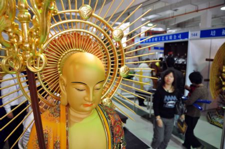 Visitors walk pass a sculpture work on the Buddhism Expo held in Putian, southeast China's Fujian Province, Nov. 2, 2009. The four-day-long China Putian Buddhism Expo kicked off here on Monday with nearly 10,000 exhibits on show.[Photo by Lin Jianbing]