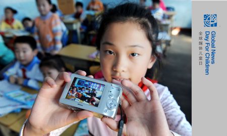 Ren Houshu shows her camera at Jilin Road Elementary School in Qingdao, a coastal city in east China's Shandong Province, Oct. 26, 2009. Ren Houshu, a nine-year-old student of 4th grade in Jilin Road Elementary School, liked playing pottery pipe and making silk flower. She always presented her handmade silk flower to friends to share the fruit of labor. She owned a poodle named Amy who seemed like her good company. Learning from books and TV she found many beautiful places around the world which inspired her traveling hobby, and therefore to enjoy fun of recording journeys by camera became her earnestly desire.