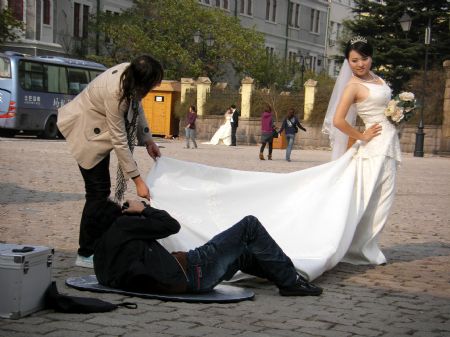 Photo taken by Ren Houshu on Oct. 24, 2009 shows that a cameraman takes photos of a bride in Qingdao, a coastal city in east China's Shandong Province. Ren Houshu, a nine-year-old student of 4th grade in Jilin Road Elementary School, liked playing pottery pipe and making silk flower. She always presented her handmade silk flower to friends to share the fruit of labor. She owned a poodle named Amy who seemed like her good company. Learning from books and TV she found many beautiful places around the world which inspired her traveling hobby, and therefore to enjoy fun of recording journeys by camera became her earnestly desire.