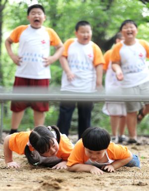 Chen Xiran (right down) crawls in the trainings in the weight-reducing summer camp held in Changsha, capital of central China